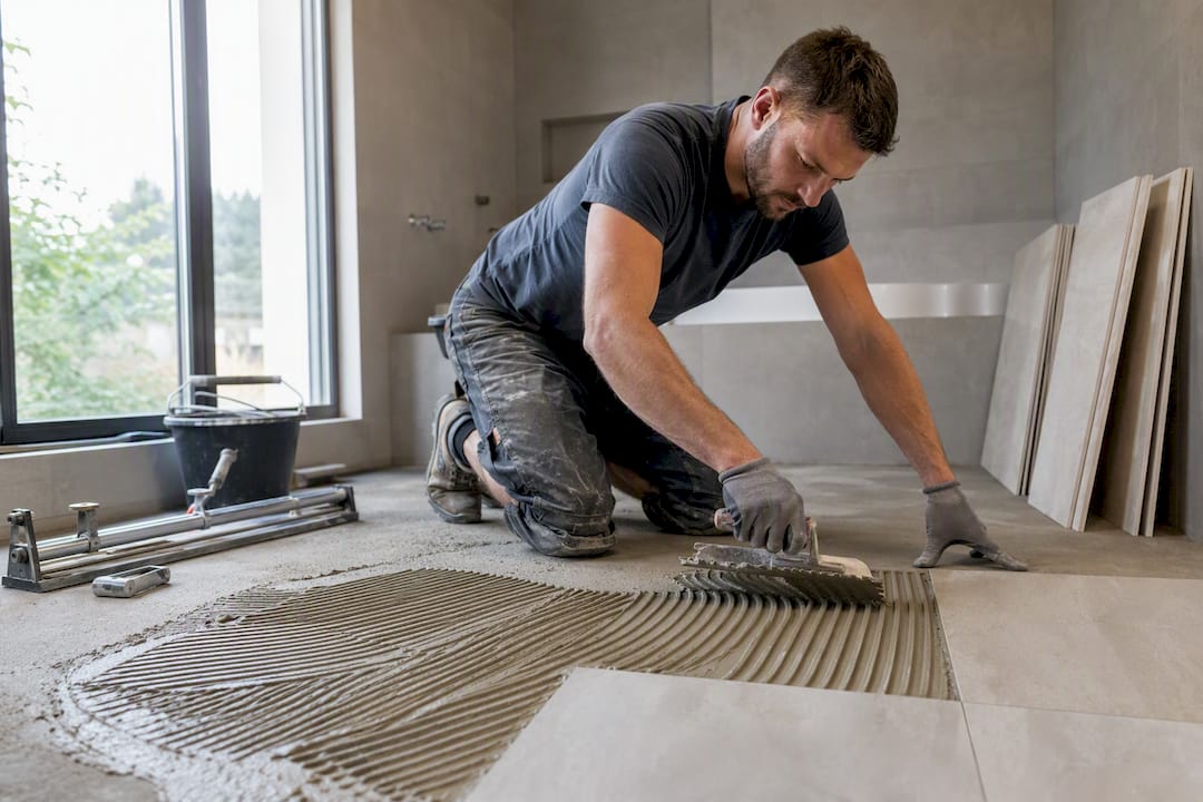 Tile contractor laying large-format bathroom floor tile